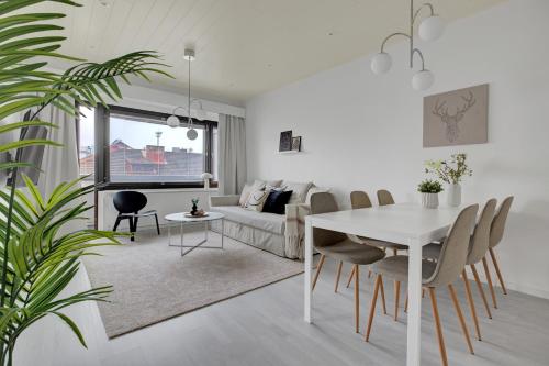 a living room with a white table and a couch at Design apartment in city center with free parking in Rovaniemi