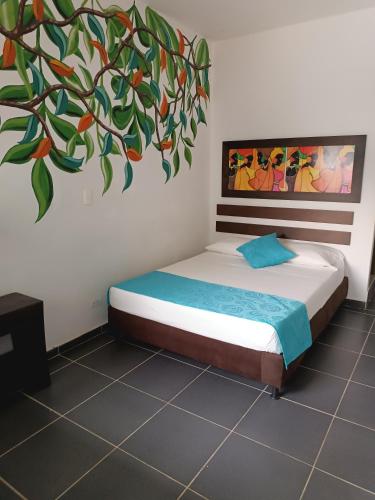 a bedroom with a bed with a painting on the wall at Hotel Villa Alicia in San Jerónimo