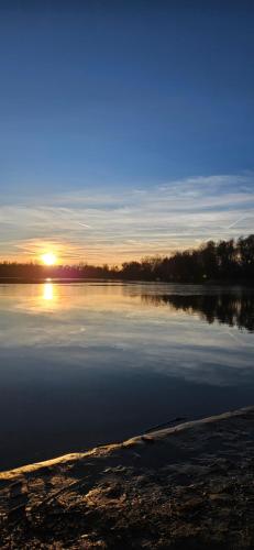 a large body of water with the sun in the background at Haus am Nymphensee2 in Brieselang