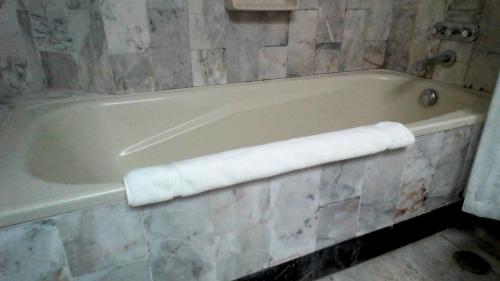 a bath tub with a towel on the side of it at Yatu Lau Lagoon Resort Fiji in Pacific Harbour
