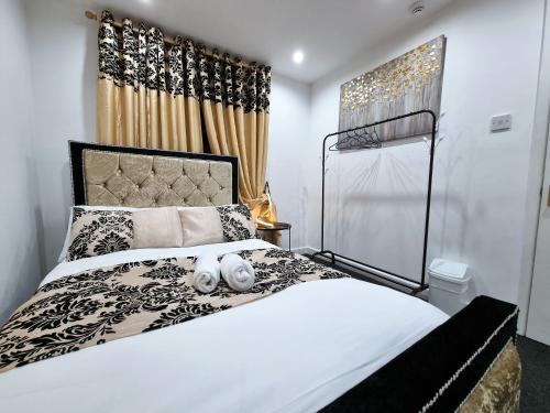 a bedroom with a black and white bed and a window at *RA1GH* For your most relaxed & Cosy stay + Free Parking + Free Fast WiFi * in Bramley
