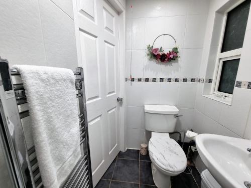 Baño blanco con aseo y lavamanos en *RA1GH* For your most relaxed & Cosy stay + Free Parking + Free Fast WiFi *, en Bramley