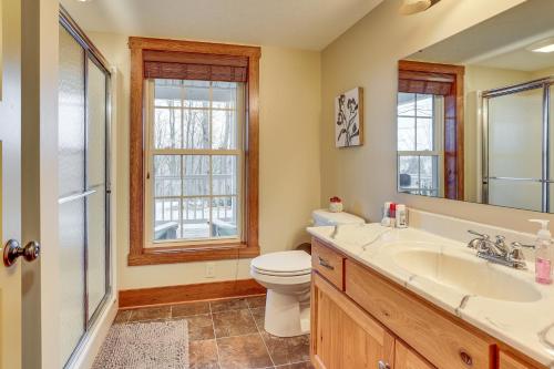 a bathroom with a toilet and a sink and a mirror at Happy Haven Hill Cabin with Patio and Fire Pit! in Dundee