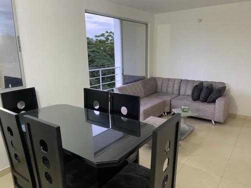 ein Wohnzimmer mit einem Glastisch und einem Sofa in der Unterkunft Apartamento en Prados del Este Amplio comodo y equipado in Cúcuta