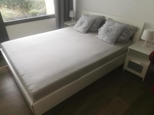 a bed with white sheets and pillows next to a window at Ferienwohnung Küstenkind in Wendtorf