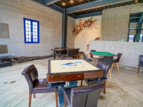 ein Zimmer mit einer Tischtennisplatte und Stühlen in der Unterkunft 嵐羽蒔光 in Yuanshan
