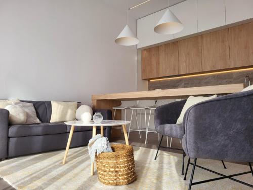 a living room with a couch and a table and chairs at Firefly Luxury Apartment with private Whirlpool in Zadar