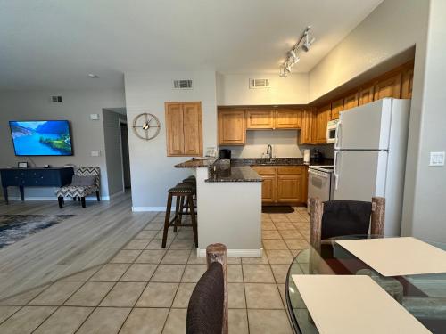 an open kitchen and living room with white appliances at Golfer’s Oasis Condominium at Hawk Ridge in Mesquite
