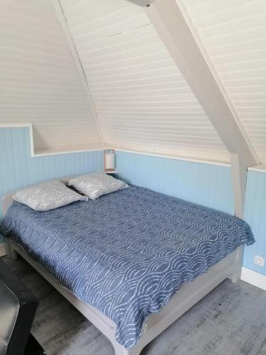un lit dans une chambre avec un mur bleu dans l'établissement Studio 6 proche du port, à Cancale
