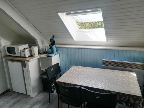 eine kleine Küche mit einem Tisch und einem Fenster in der Unterkunft Studio 2 proche du port in Cancale