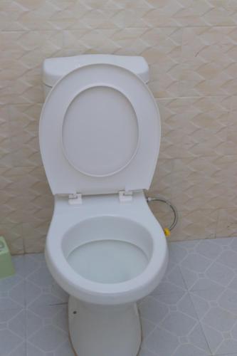 - des toilettes blanches avec un couvercle dans la salle de bains dans l'établissement Palacio de Mewic, à Lilongwe
