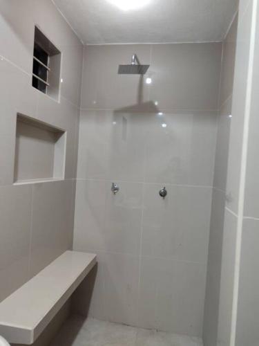 a white bathroom with a shower and a toilet at Departamento minimalista in Poza Rica de Hidalgo