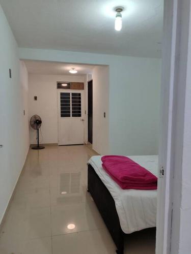 Un dormitorio con una cama con una manta roja. en Departamento minimalista, en Poza Rica de Hidalgo