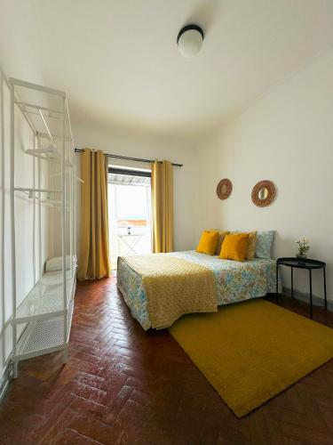 リスボンにあるCasas da Eva - Campolideのベッドルーム1室(黄色い枕のベッド1台付)