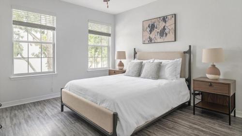 ein weißes Schlafzimmer mit einem großen Bett und zwei Fenstern in der Unterkunft Landing Modern Apartment with Amazing Amenities (ID3821X91) in Orlando