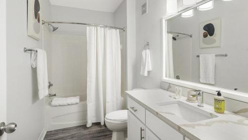 La salle de bains blanche est pourvue d'un lavabo et de toilettes. dans l'établissement Landing Modern Apartment with Amazing Amenities (ID3821X91), à Orlando