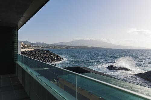 a view of the ocean from the balcony of a building at SeaLux Apartment (Seaside) in São Roque