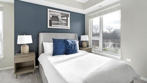 沃倫維爾的住宿－Landing Modern Apartment with Amazing Amenities (ID5350X87)，一间卧室设有一张带蓝色墙壁和窗户的大床