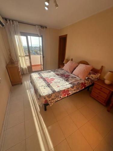 um quarto com uma cama num quarto com uma janela em Casa en las buganvillas Vera Playa em Playas de Vera