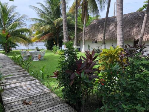 a wooden path leading to a resort with palm trees at Casa de playa, en isla, frente al mar y canal in Iztapa
