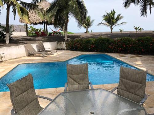 - une table et des chaises à côté de la piscine dans l'établissement Casa de playa, en isla, frente al mar y canal, à Iztapa