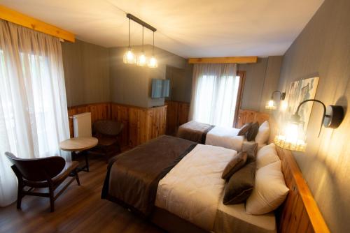 a hotel room with a bed and a table and chairs at Ayder Koru Hotel in Ayder Yaylasi