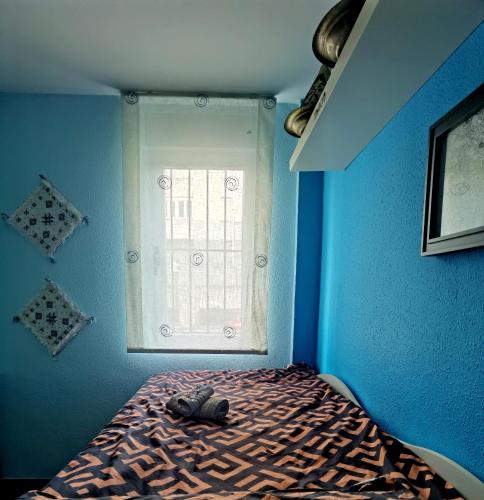 a blue room with a bed with a window at Ganga Room 2 in Bilbao
