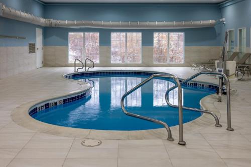 a swimming pool in a building with blue water at Holiday Inn Express Hotel & Suites Center Township, an IHG Hotel in Monaca