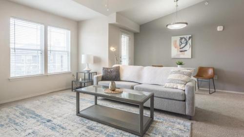 un soggiorno con divano e tavolo di Landing Modern Apartment with Amazing Amenities (ID8475X47) a Baton Rouge