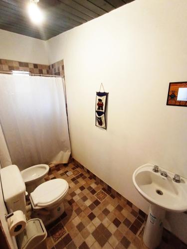 a bathroom with a toilet and a sink at Hostal La Albahaca in Tilcara