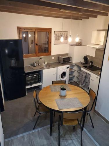 une cuisine avec une table et des chaises dans une cuisine dans l'établissement Maison avec extérieur à 5 min du futuroscope, à Jaunay-Clan