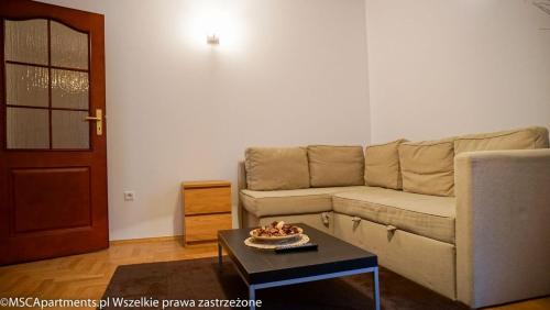 salon z kanapą i stolikiem kawowym w obiekcie MSC Apartments Zaciszny w Zakopanem