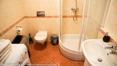 a bathroom with a toilet and a shower and a sink at MSC Apartments Zaciszny in Zakopane