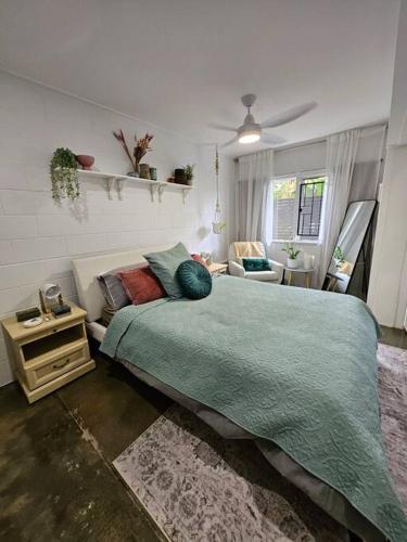 a bedroom with a large bed with a green blanket at Prime location: Just steps away from Oxford Street in Brisbane