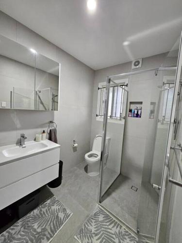 a bathroom with a shower and a sink and a toilet at Prime location: Just steps away from Oxford Street in Brisbane