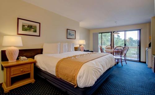 a hotel room with a bed and a table and chairs at Aspinquid Resort in Ogunquit