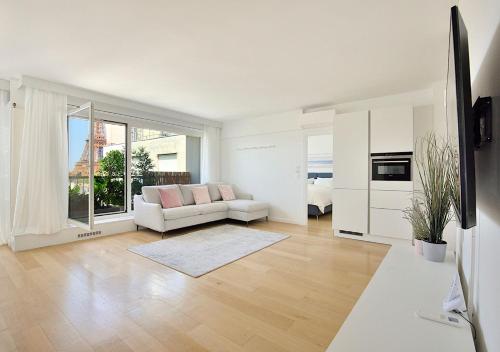 un salon blanc avec un canapé et une table dans l'établissement Top Floor Million Dollar View Eiffel Tower, 2 beds, 4 people, à Paris