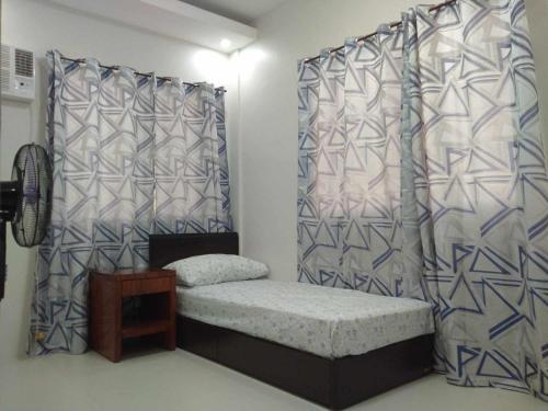 una camera con un letto con tende e un tavolo di Millenia Oaks Apartments a Subic