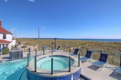 a large swimming pool with chairs and a swimming poolvisor at Waves Oceanfront Resort in Old Orchard Beach