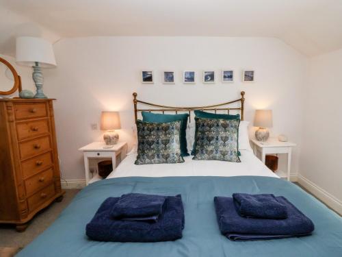 a bedroom with a bed with blue towels on it at Cobblers Cottage, Southwold in Southwold