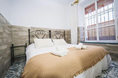 een slaapkamer met een groot bed en handdoeken bij Apartamento en el barrio de San Lorenzo, junto a la Basílica del Gran Poder in Sevilla