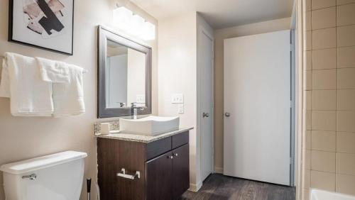 a bathroom with a sink and a toilet and a mirror at Landing Modern Apartment with Amazing Amenities (ID5072X49) in Austin