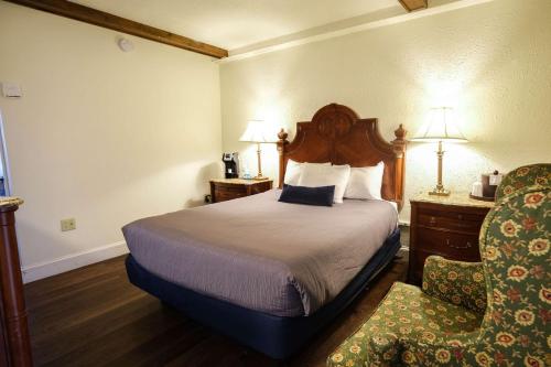 una camera d'albergo con letto e sedia di Fireside Inn and Suites Bangor a Bangor