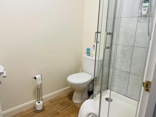 a bathroom with a toilet and a glass shower at AlphaStudio-Leeds-Walk 2-City-Centre-FreePark-Wifi in Leeds