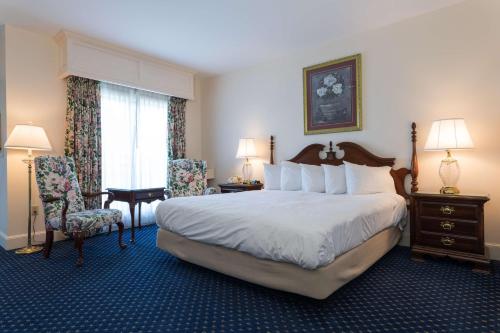 a hotel room with a large bed and a chair at Bluenose Inn - Bar Harbor Hotel in Bar Harbor