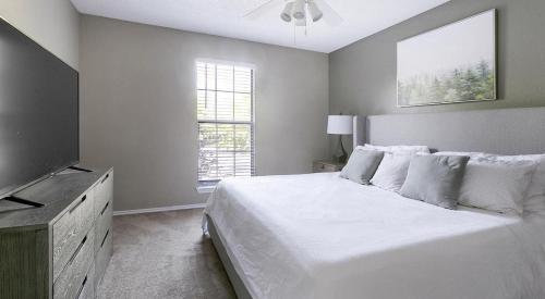 a white bedroom with a bed and a flat screen tv at Landing Modern Apartment with Amazing Amenities (ID7025X65) in Cincinnati