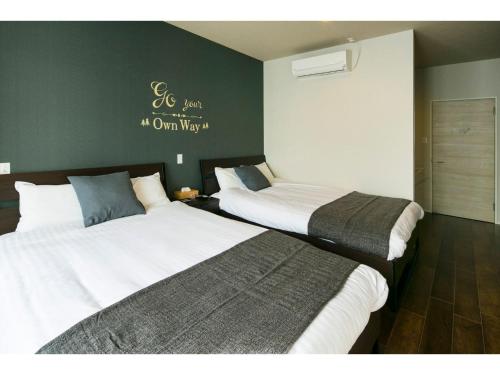 two beds in a hotel room with at ROI SPACE KAGOSHIMA - Vacation STAY 87745 in Kagoshima