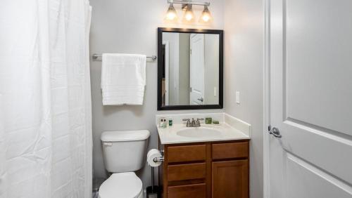 een badkamer met een toilet, een wastafel en een spiegel bij Landing Modern Apartment with Amazing Amenities (ID7168X66) in Dublin