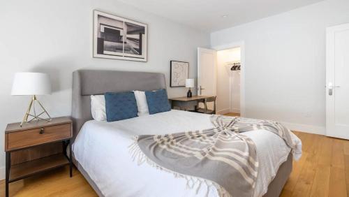 een slaapkamer met een bed en een tafel met een lamp bij Landing Modern Apartment with Amazing Amenities (ID7294X83) in Somerville