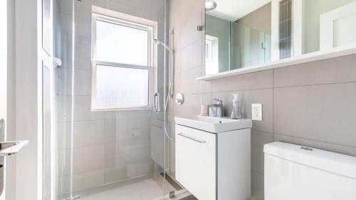 een witte badkamer met een toilet en een wastafel bij Landing Modern Apartment with Amazing Amenities (ID7294X83) in Somerville